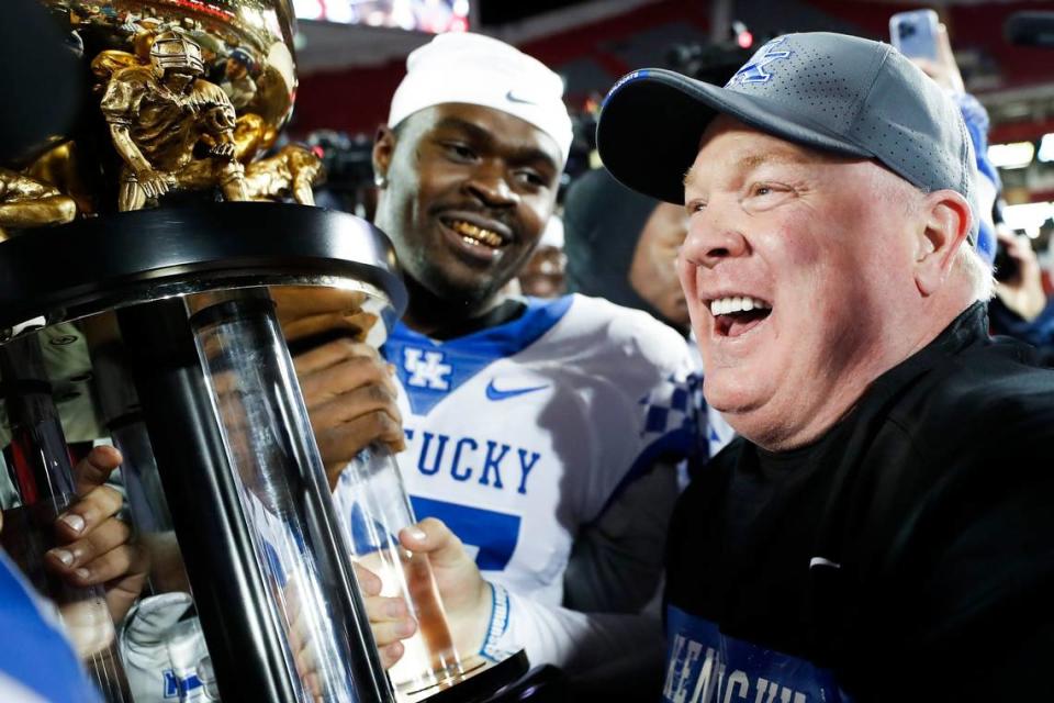 Kentucky head coach Mark Stoops celebrates with his team and the Governors Cup trophy after their 52-21 defeat of Louisville at Cardinal Stadium on Nov. 27, 2021.