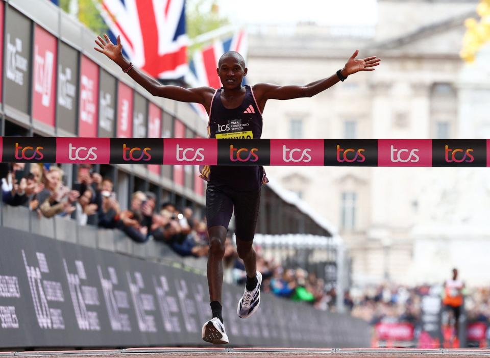 Kenya's Alexander Munyao claims glory in the men't race with Bekele in the distance