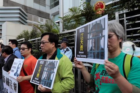 Pro-democracy demonstrators hold up portraits of Chinese disbarred lawyer Jiang Tianyong, demanding his release, during a demonstration outside the Chinese liaison office in Hong Kong, China December 23, 2016. REUTERS/Tyrone Siu