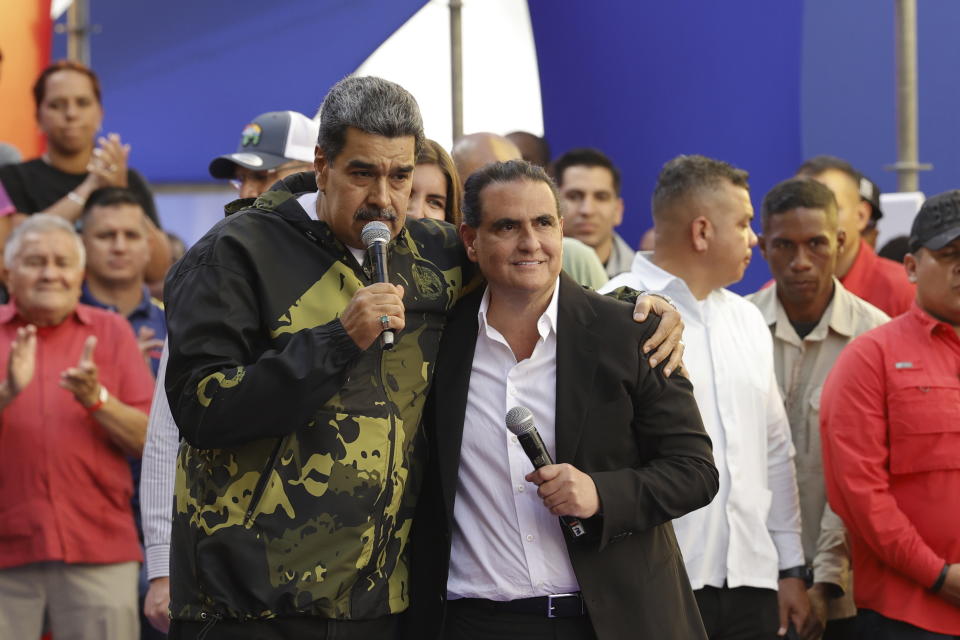 File - Venezuela's President Nicolas Maduro and Alex Saab stand in an embrace during an event marking the anniversary of the 1958 coup that overthrew dictator Marcos Perez Jimenez, in Caracas, Venezuela, Jan. 23, 2024. A Venezuelan businessman who helped hide almost $17 million in bribe payments by an ally of President Nicolas Maduro was sentenced to six months in prison Friday, Feb. 16, 2024, by a federal judge. (AP Photo/Jesus Vargas, File)