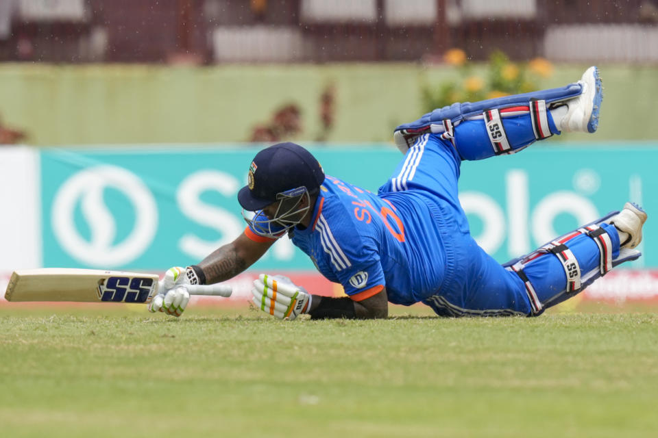 India's Suryakumar Yadav falls after hitting six from a delivery of West Indies' Romario Shepherd during the third T20 cricket match at Providence Stadium in Georgetown, Trinidad and Tobago, Tuesday, Aug. 8, 2023. (AP Photo/Ramon Espinosa)