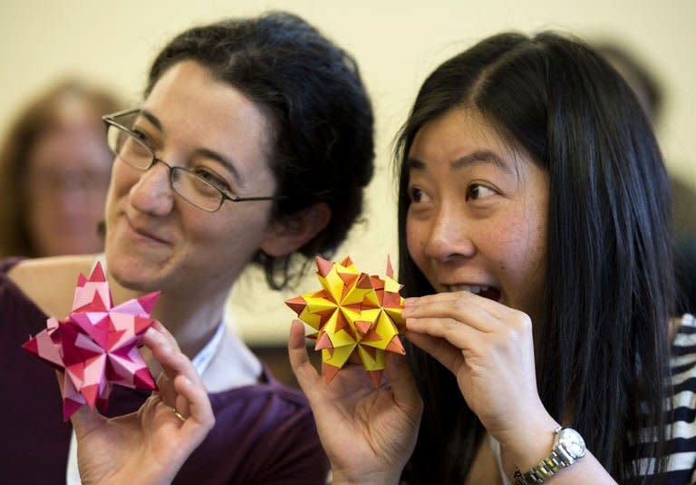 Two women smile with their Bascetta Stars during an Origami class at the Origami Convention 2013 at the Fashion Institute of technology in New York, June 22, 2013. Hundreds of enthusiasts gathered in New York over the weekend for a convention celebrating origami, the ancient Asian art of paper folding, as the craft gains increasing recognition as serious art in the West