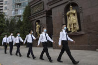 Security guards wearing masks to curb the spread of the coronavirus march past a community with European style statues in Beijing on Monday, June 29, 2020. Even as the world surpassed two sobering coronavirus milestones Sunday -- 500,000 confirmed deaths, 10 million confirmed cases -- and hit another high mark for daily new infections, China on Monday reported a further decline in new confirmed cases. (AP Photo/Ng Han Guan)