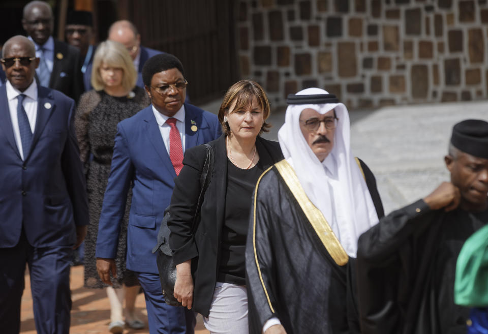 President of the Swiss National Council Marina Carobbio Guscetti, center, arrives to lay a wreath at the Kigali Genocide Memorial in Kigali, Rwanda Sunday, April 7, 2019. Rwanda is commemorating the 25th anniversary of when the country descended into an orgy of violence in which some 800,000 Tutsis and moderate Hutus were massacred by the majority Hutu population over a 100-day period in what was the worst genocide in recent history. (AP Photo/Ben Curtis)