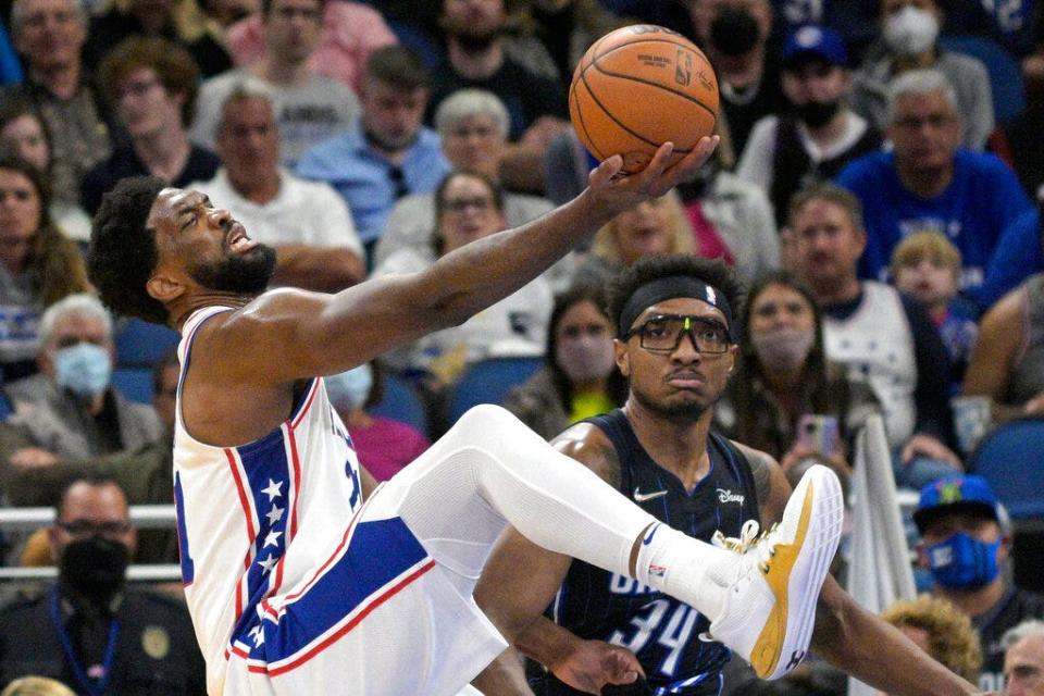 Sixers center Joel Embiid is fouled by the Magic's Wendell Carter Jr. while going for a rebound.