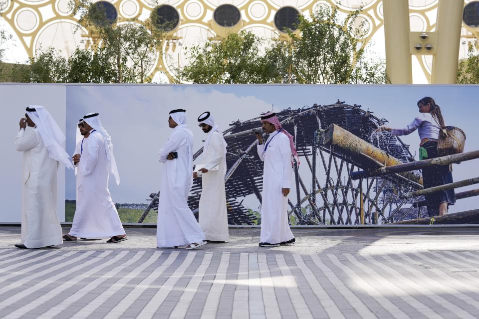 People walk near the Al Wasl Dome at Expo City ahead of the COP28 U.N. Climate Summit, Tuesday, Nov. 28, 2023, in Dubai, United Arab Emirates. (AP Photo/Kamran Jebreili)