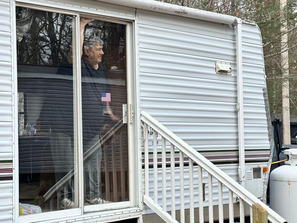 Vietnam War veteran and former Eliot police chief Tom Barr, 76, watches from his camper as a new mobile home is brought up his driveway. The home is a gift from hundreds of community members who donated to replace his previous home that was infested with black fungus.