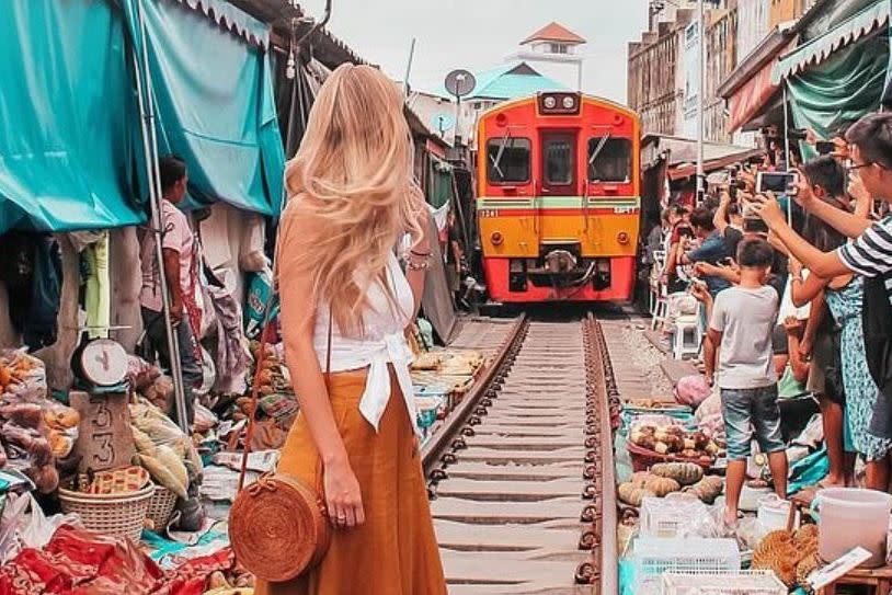 Patricia Alejos Monzon posed in front of a train at Maeklong Railway Market: Instagram/oneoceanaway