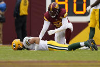 Green Bay Packers quarterback Aaron Rodgers (12) lays on the turf with Washington Commanders defensive end James Smith-Williams (96) over him after an NFL football game Sunday, Oct. 23, 2022, in Landover, Md. The Commanders won 23-21. (AP Photo/Patrick Semansky)