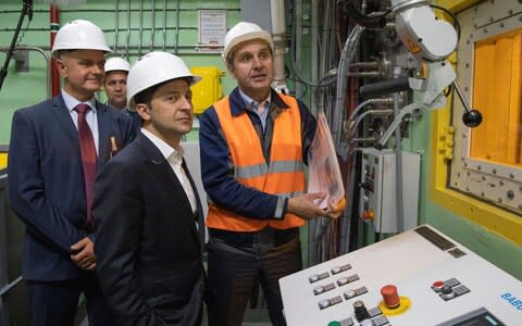 Volodymyr Zelenskiy, foreground, visits the 'new safe confinement' shelter over the remains of Chernobyl's reactor number four - Credit: Ukrainian Presidential Press Office via AP