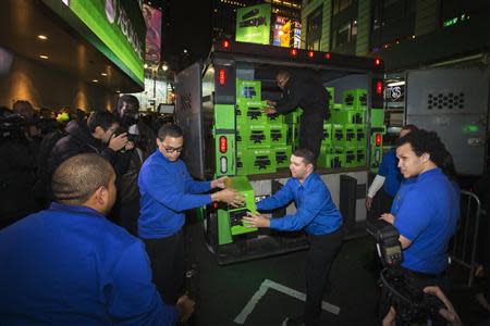 Best Buy employees work to unload an armored vehicle filled with Day One edition Xbox One consoles for a midnight launch event in New York, November 21, 2013. REUTERS/Lucas Jackson