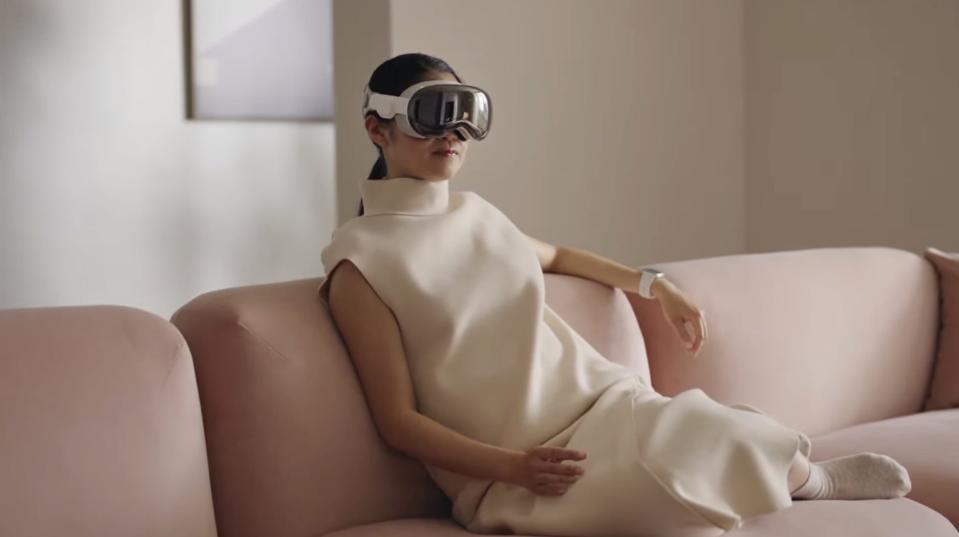 Apple Vision Pro on a woman's face, she is lounging on a couch.