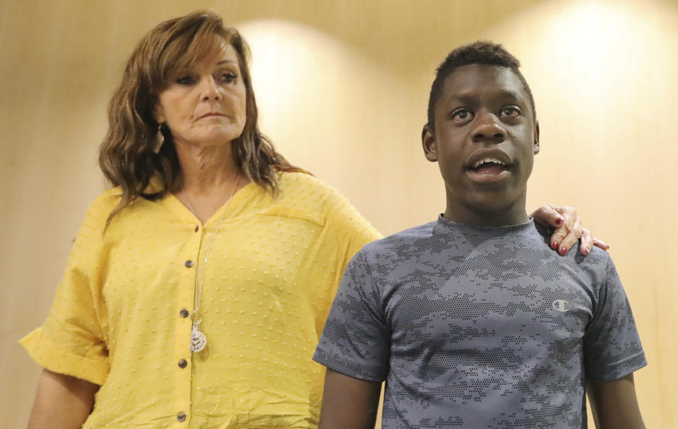 Jerri Hrubes stands next to her son DJ during a news conference Friday, June 7, 2019, in Salt Lake City. Hrubes is calling for an independent investigation after she says a police officer pointed a gun at her 10-year-old son's head in what she calls a racially motivated incident. Hrubes said that a white Woods Cross police officer pulled his gun on her son, DJ, who is black, while he was playing on the front lawn Thursday, June 6, 2019. She says the officer came back to apologize after she called to complain, but that she wants the officer and the agency held accountable. (AP Photo/Rick Bowmer)
