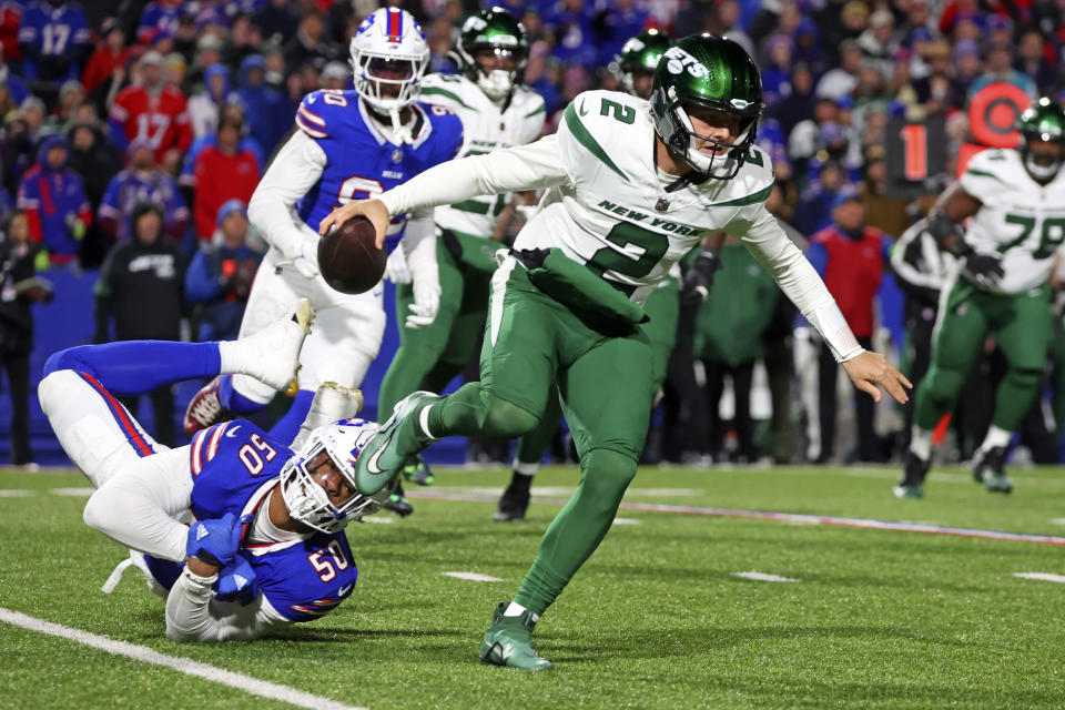 New York Jets quarterback Zach Wilson (2) slips the tackle attempt by Buffalo Bills defensive end Greg Rousseau (50) during the first half of an NFL football game in Orchard Park, N.Y., Sunday, Nov. 19, 2023. (AP Photo/Jeffrey T. Barnes)