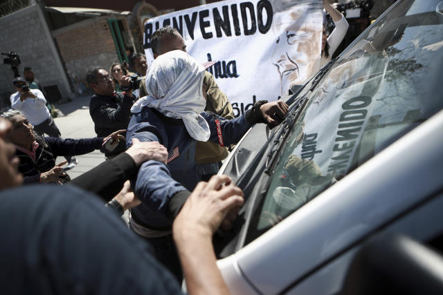 Migrants and activists try to stop a vehicle transporting Mexican President Andres Lopez Obrador during his visit to Ciudad Juarez, Mexico, Friday, March 31, 2023. Mexico’s president promised to visit hospitals treating the migrants injured in the recent fire at a dormitory at a detention center in Ciudad Juarez where more than three dozen migrants died. (AP Photo/Christian Chavez)