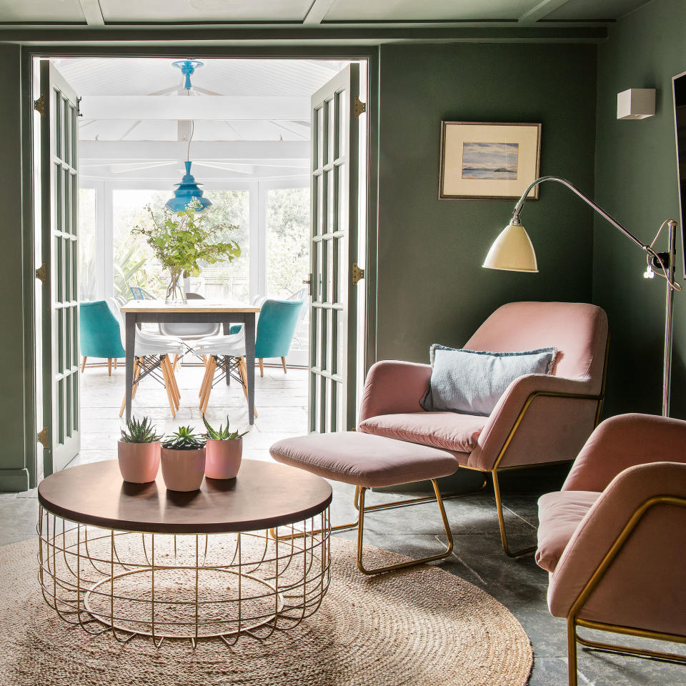 Green living room with sisal rug, two pink armchairs and floor light