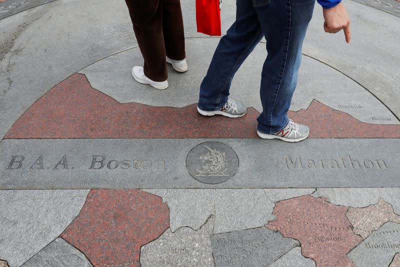 Passers-by point to the Boston marathon plaque, one day before the five year anniversary of the Boston Marathon bombings, in Boston