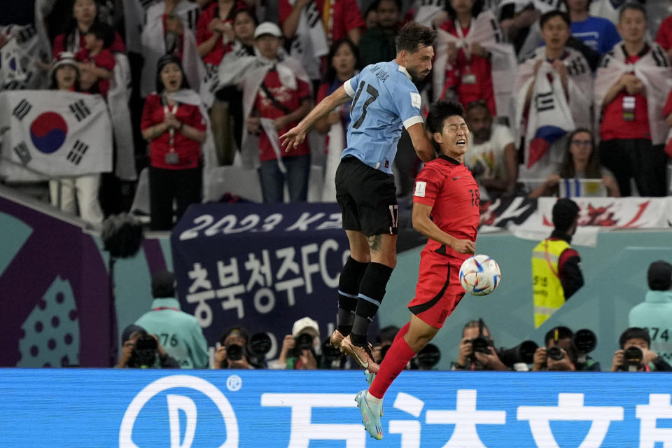 South Korea's Lee Kang-in, right, and Uruguay's Matias Vina go for a header during the World Cup group H soccer match between Uruguay and South Korea, at the Education City Stadium in Al Rayyan , Qatar, Thursday, Nov. 24, 2022. (AP Photo/Martin Meissner)