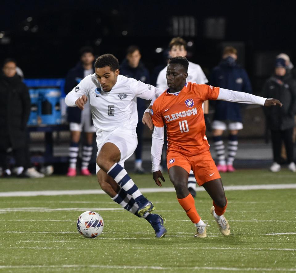 University of New Hampshire senior Yannick Bright moves the ball up the field ahead of a Clemson defender in last month's NCAA men's soccer tournament match in Durham.