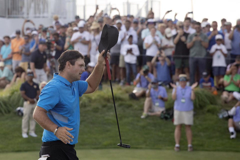 Patrick Reed tips his cap on the 18th hole as he wins on the Northern Trust golf tournament at Liberty National Golf Course, Sunday, Aug. 11, 2019, in Jersey City, N.J. (AP Photo/Mark Lennihan)