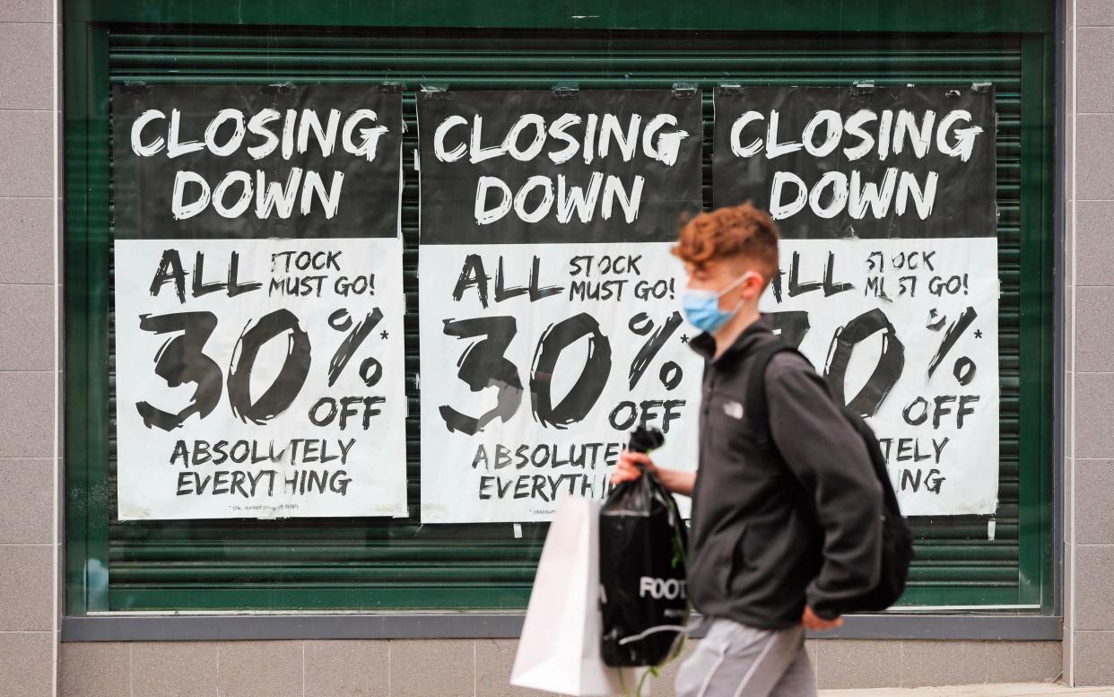 Man with face mask walks in front of a high street shop with a closing down notice in the window as coronavirus continues to hurt retailers - Mike Egerton/PA