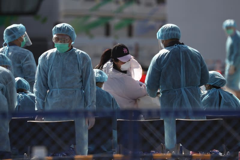 Passengers wearing masks leave cruise ship Diamond Princess at Daikoku Pier Cruise Terminal in Yokohama