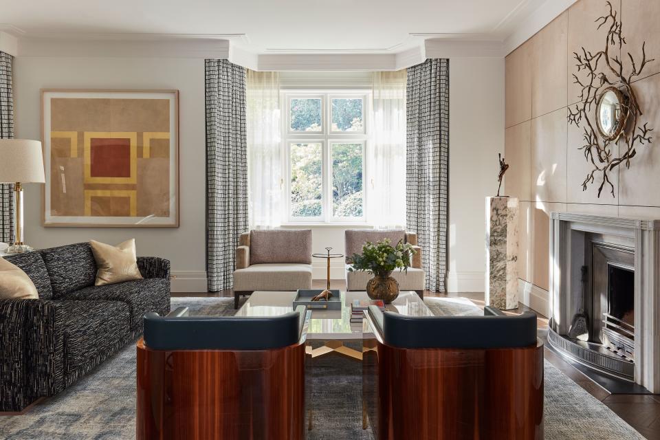 Running across the front of the house, the drawing room provides intimacy and warmth through elements such as the Luke Irwin rug, curved Liaigre armchairs, and organic bronze mirror by Hervé van der Straeten. This contrasts with the champagne-colored birdseye maple paneling made by Irish furniture brand Zelouf & Bell, which represented in New York by Maison Gerard. Notably, metallic elements pick up the evening light, such as the artwork by Patrick Scott and the 1950s side table from Michael Mortell Gallery. The curtains were made by Mary Wrynne using fabric by Christopher Farr while the plinth was bought at Bernard Tinivella in Paris.