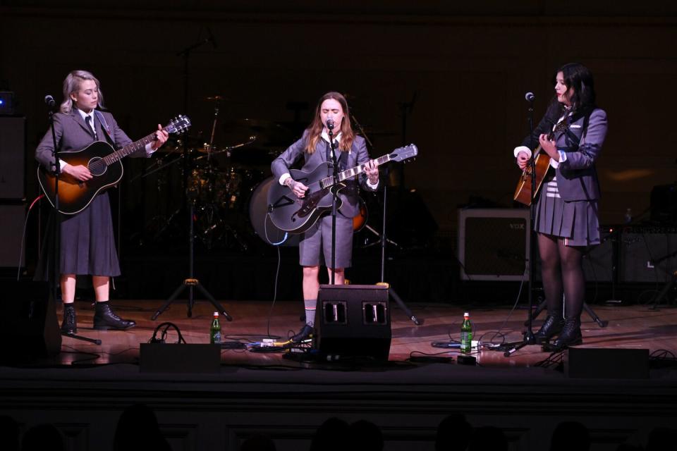 A female rock band performs onstage