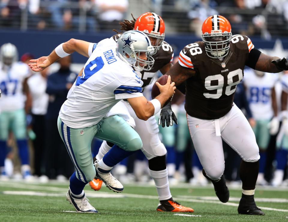 Nov 18, 2012; Arlington, TX, USA; Dallas Cowboys quarterback Tony Romo (9) scrambles away from Cleveland Browns defensive tackle Phil Taylor (98) and defensive end Jabaal Sheard (97) at Cowboys Stadium. Mandatory Credit: Matthew Emmons-USA TODAY Sports