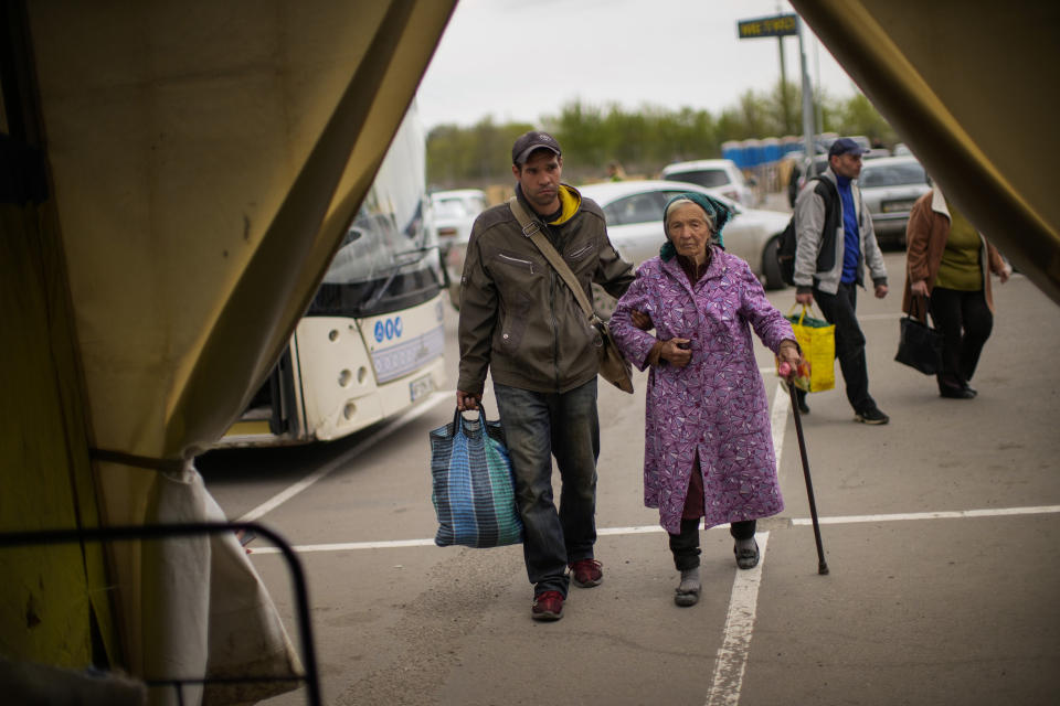 Kateryna Hodza, 85, and her grandson Artem Dorschenko arrive at a reception center for displaced people in Zaporizhzhia, Ukraine, Friday, April 29, 2022. (AP Photo/Francisco Seco)