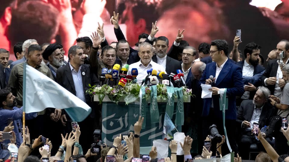 Reformist lawmaker and Iran's 2024 presidential candidate, Masoud Pezeshkian (C), speaks while his supporters flash victory signs during an electoral campaign rally at a sports complex in downtown Tehran, Iran, on June 23. - Morteza Nikoubazl/NurPhoto/Shutterstock