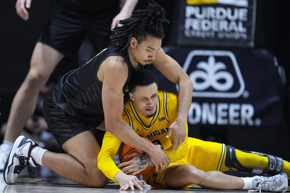 Purdue forward Trey Kaufman-Renn (4) and Michigan guard Jaelin Llewellyn (3) go to the floor for a loose ball during the second half of an NCAA college basketball game in West Lafayette, Ind., Tuesday, Jan. 23, 2024. (AP Photo/Michael Conroy)