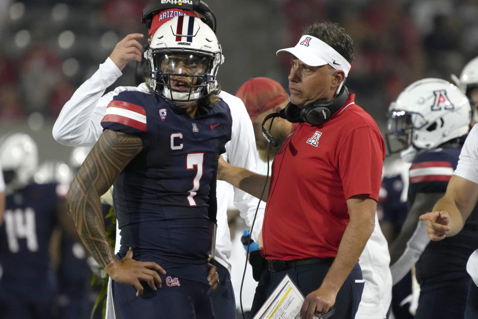 Arizona quarterback Jayden de Laura (7) and coach Jedd Fisch watch a replay during the first half of the team's NCAA college football game against Northern Arizona, Saturday, Sept. 2, 2023, in Tucson, Ariz. (AP Photo/Rick Scuteri)