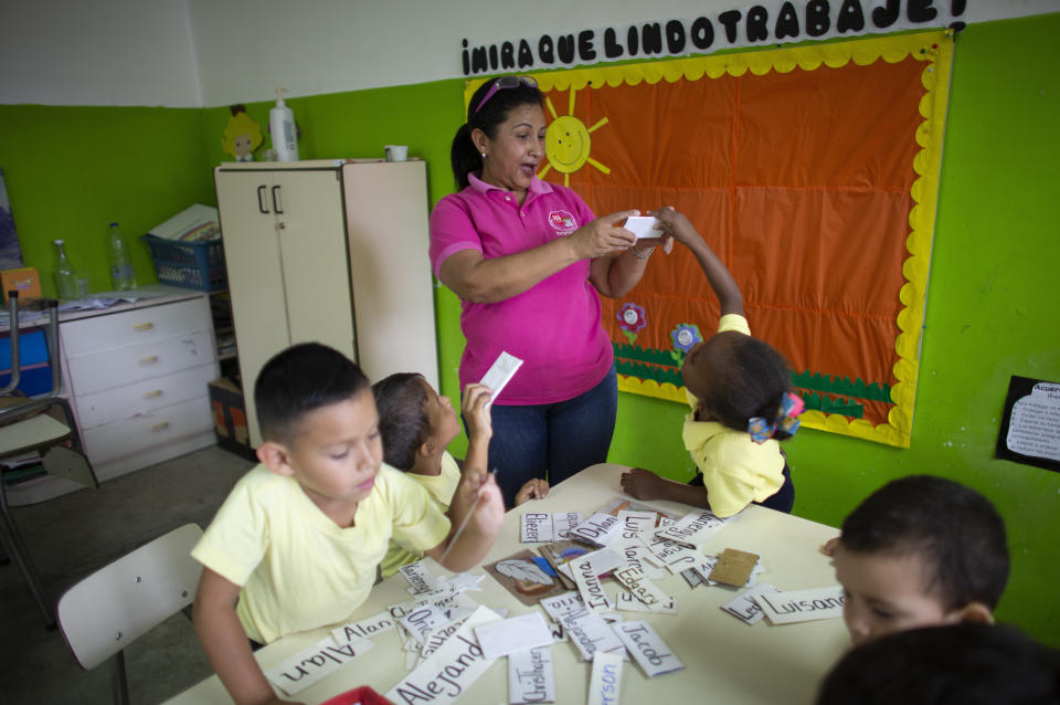 In this Oct. 7, 2019 photo, teacher Daixy Aguero teaches a class at a school in Caracas, Venezuela. Nearly half of the Venezuela's teachers have fled the country in the last three years, according to the workers' union representing educators. They're escaping low pay and crumbling classrooms. (AP Photo/Ariana Cubillos)
