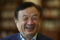 In this Aug. 20, 2019, photo, Huawei's founder Ren Zhengfei reacts as he chats with Huawei executives at the company campus in Shenzhen in Southern China's Guangdong province. Ren says its troubles with President Donald Trump are hardly the biggest crisis he has faced while working his way from rural poverty to the helm of China’s first global tech brand. (AP Photo/Ng Han Guan)