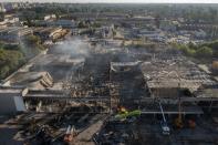 FILE - Ukrainian State Emergency Service firefighters work to take away debris at a shopping center burned after a rocket attack in Kremenchuk, Ukraine, Tuesday, June 28, 2022. While much of the attritional war in Ukraine’s east is hidden from sight, the brutality of Russian missile strikes in recent days on the mall in the central city of Kremenchuk and on residential buildings in the capital, Kyiv, were in full view to the world and especially to Western leaders gathered for a trio of summits in Europe. (AP Photo/Efrem Lukatsky, File)