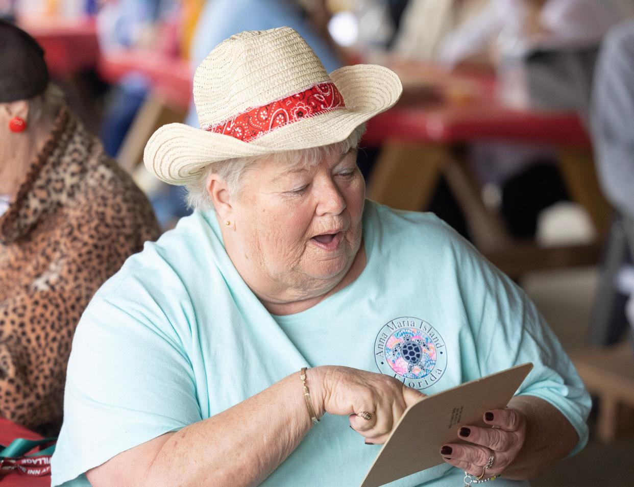 Debbie Stranger realizes she's a winner while playing bingo at the Massillon Senior Center's western-themed barbecue.