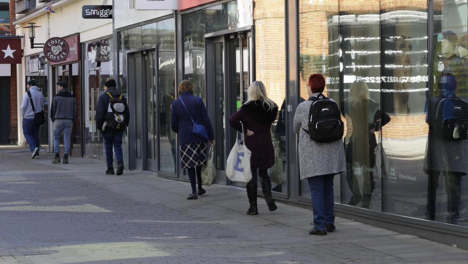 FILE - In this Tuesday, March 24, 2020 file photo, people use social distancing to prevent the spread of coronavirus, as they queue to enter a supermarket in Windsor, England. A pandemic forcing everyone to stay home could be the perfect moment for online grocery services. In practice, they've been struggling to keep up with a surge in orders, highlighting their limited ability to respond to an unprecedented onslaught of demand. After panic buying left store shelves stripped of staples like pasta, canned goods and toilet paper, many shoppers quickly found online grocery delivery slots almost impossible to come by, too. (AP Photo/Kirsty Wigglesworth, File)