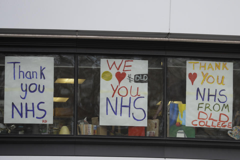 FILE - In this Tuesday, March 31, 2020 signs in support of the British National Health Service staff who are fighting the coronavirus outbreak put up by students at the DLD College near St Thomas' Hospital, one of the many hospitals dealing with coronavirus patients in London. (AP Photo/Kirsty Wigglesworth, File)