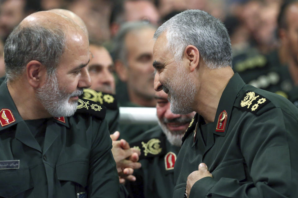 In this undated photo released by an official website of the office of the Iranian supreme leader, Ali Akbar Ahmadian, the former chief of the paramilitary Revolutionary Guard's strategic center, left, sits next to the late Revolutionary Guard Gen. Qassem Soleimani, in Tehran, Iran. Iran's president on Monday appointed Ahmadian to take over the post of secretary of the country's Supreme National Security Council, replacing the longtime powerful official Ali Shamkhani after becoming implicated in a recent spy scandal. (Office of the Iranian Supreme Leader via AP)