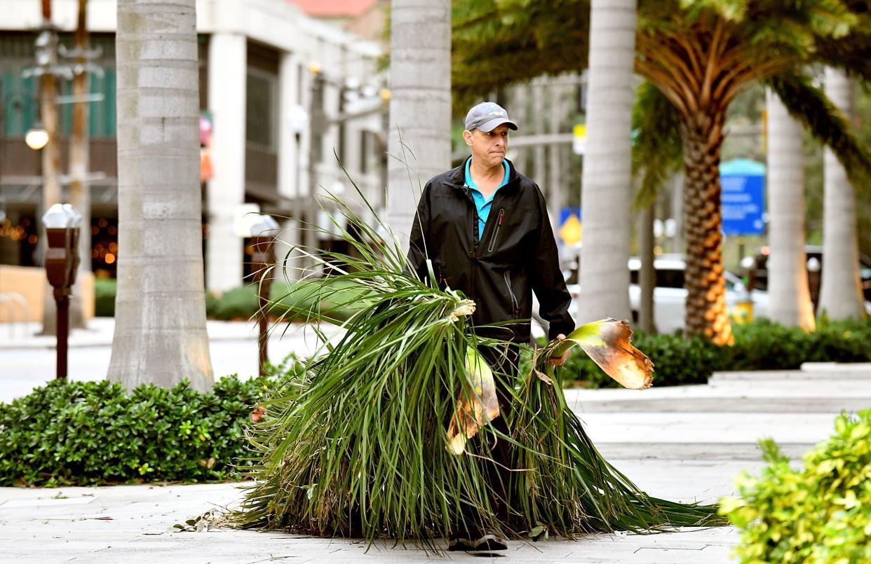 A local resident cleans debris in downtown Saint Petersburg after Hurricane Ian passed through the area on Sept. 29, 2022, in Saint Petersburg, Fla. The hurricane brought high winds, storm surge and rain to the area, causing severe damage.