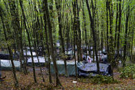 Migrants stand around improvised tents in a makeshift camp in the woods outside Velika Kladusa, Bosnia, Saturday, Sept. 26, 2020.(AP Photo/Kemal Softic)