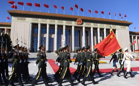 Chinese soldiers march out to form an honour guard for Shinzo Abe outside the Great Hall of the People, Beijing  - Credit: GREG BAKER/AFP/Getty Images