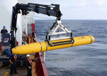 Crew aboard the Australian Defence Vessel Ocean Shield move the U.S. Navy's Bluefin-21 autonomous underwater vehicle into position for deployment in the southern Indian Ocean to look for the missing Malaysia Airlines flight MH370 April 14, 2014 in this file handout picture released by the U.S. Navy. Malaysia on August 28, 2014 said it would share with Australia the cost of the latest effort to uncover signs of the missing flight MH370, in the hope of unlocking modern aviation's greatest mystery. REUTERS/U.S. Navy photo by Mass Communication Specialist 1st Class Peter D. Blair/Handout via Reuters/Files