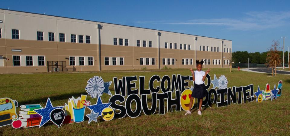 Sariah Morris, a fifth-grader, poses Friday morning outside South Pointe Elementary. She was among about 500 students enrolled at the newly opened school.