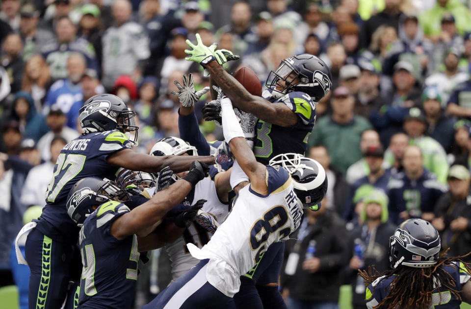 Seattle Seahawks free safety Tedric Thompson, upper right, intercepts a pass above Los Angeles Rams wide receiver Josh Reynolds (83) in the end zone for a touchback during the first half of an NFL football game, Sunday, Oct. 7, 2018, in Seattle. (AP Photo/Elaine Thompson)