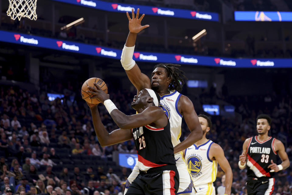 Portland Trail Blazers center Duop Reath (26) shoots against Golden State Warriors forward Kevon Looney, back, during the first half of an NBA basketball game in San Francisco, Wednesday, Dec. 6, 2023. (AP Photo/Jed Jacobsohn)