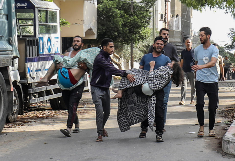 Civil defense teams and residents carry injured people on Tuesday after an Israeli attack in Rafah.