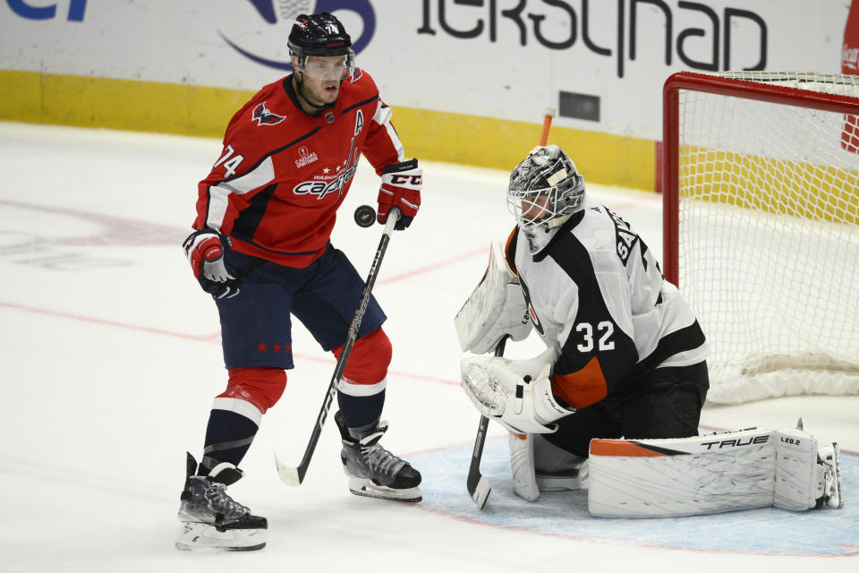 Washington Capitals defenseman John Carlson (74) and Philadelphia Flyers goaltender Felix Sandstrom (32) battle for the puck during overtime of an NHL hockey game, Wednesday, Nov. 23, 2022, in Washington. The Capitals won 3-2 in overtime. (AP Photo/Nick Wass)