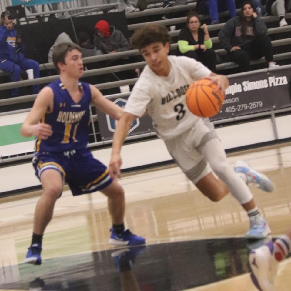 Meeker's Treyvon Compton (3) drives the basketball against the defense of Holdenville's Julius Jackson Thursday night.